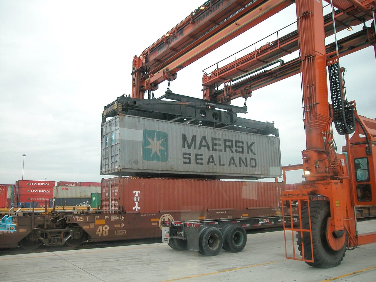 A container being lifted by a reach stacker at an intermodal terminal